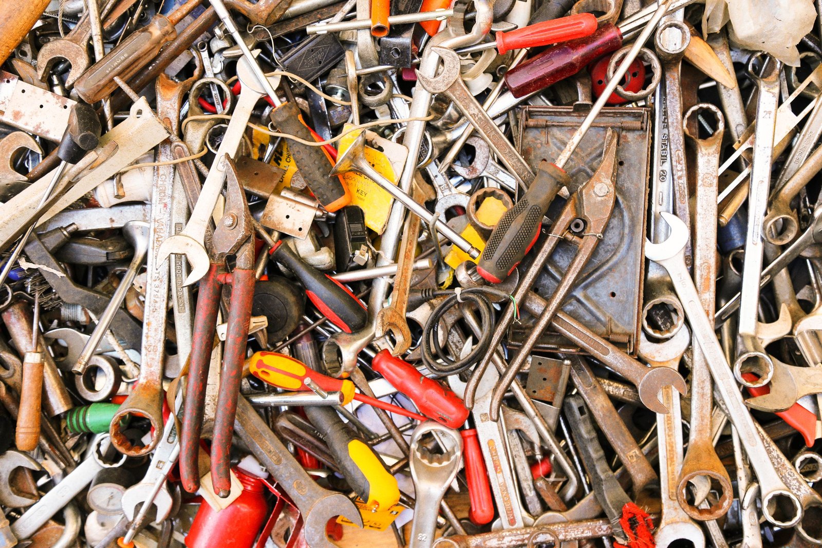 A vibrant assortment of various hand tools arranged in a pile. Ideal for construction themes.